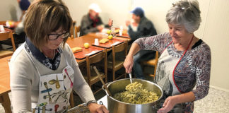volontari servono la cena nella mensa al Convento dei frati Cappuccini
