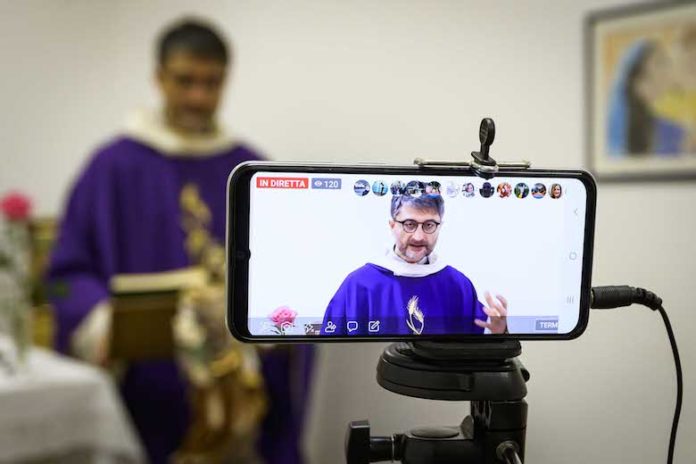 Roma, 12 marzo 2020. Don Maurizio Mirilli, parroco della parrocchia del SS. Sacramento a Roma. Santa Messa in streaming e distribuzione della Eucarestia per essere comunque vicini alla comunità parrocchiale durante il periodo del Coronavirus.