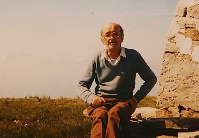 Il,poeta Tavio Cosio seduto su una pietra in campagna