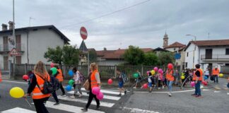 bambini e accompagnatori del pedibus mentre attraversano una strada